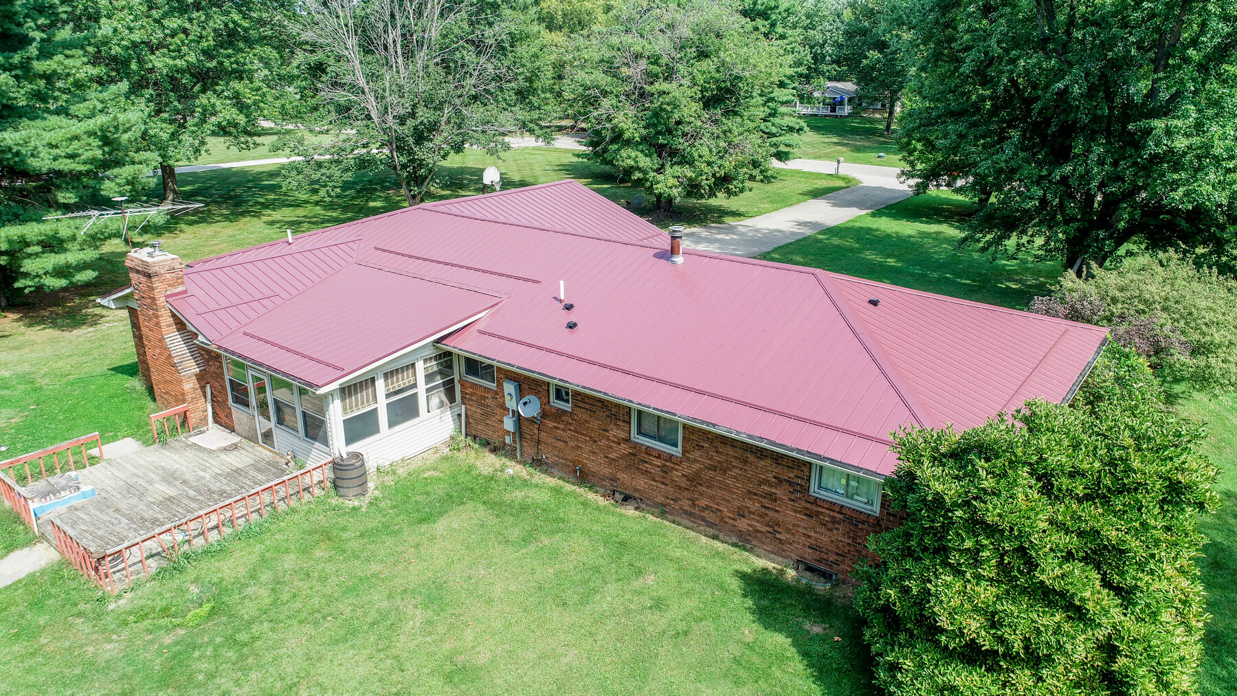 Berry burgundy metal roof on a brick ranch home in Central Ohio