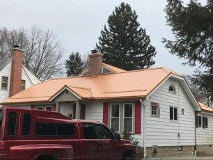 Copper-colored metal roof on a white cottage in Central Ohio