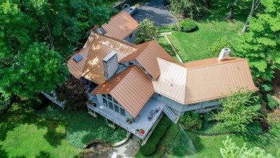 Copper penny standing-seam metal roof with skylights and snow guards
