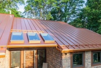 Copper-colored standing-seam metal roof with skylights on an Ohio home