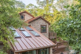 Copper-colored standing-seam roof with skylights and snow bars