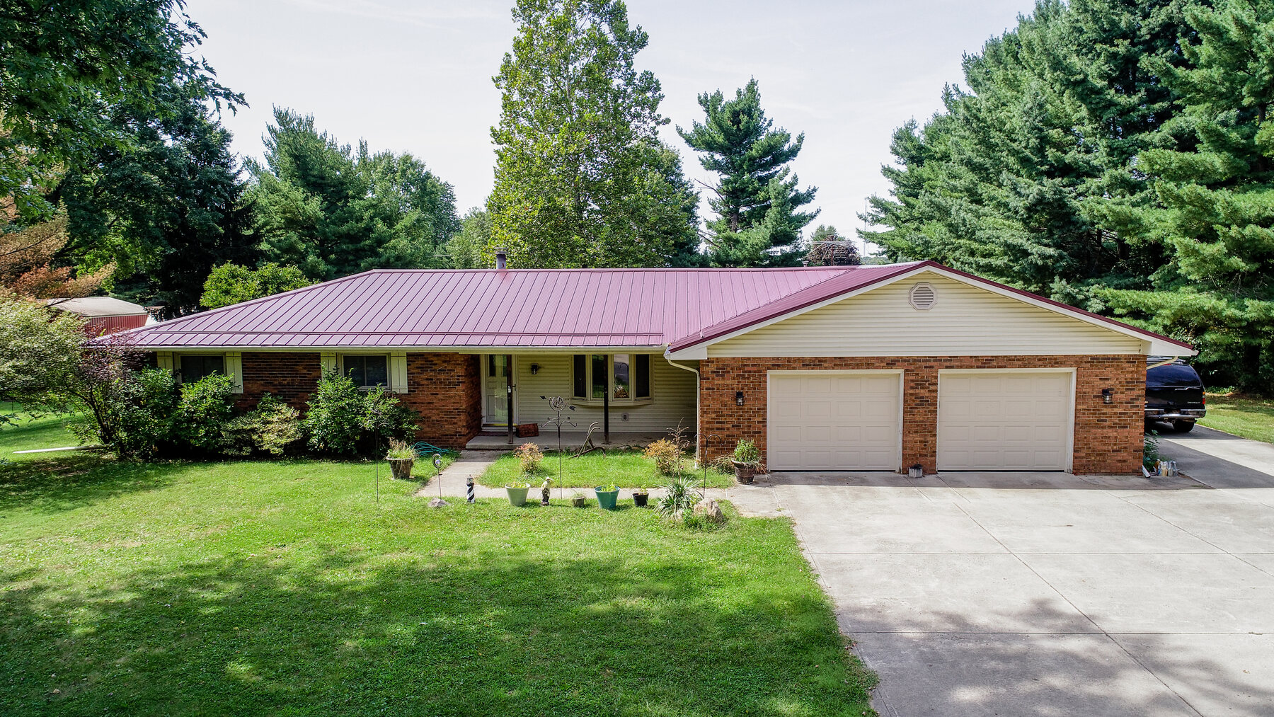Dark burgundy metal roof on a brick ranch home in Central Ohio